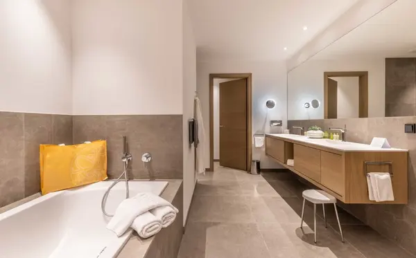 Modernes Badezimmer mit Badewanne, Doppelwaschbecken, Spiegel und stilvoller Einrichtung.