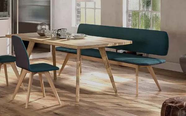 Modernes Esszimmer mit Holztisch, Bank und Stuhl auf Parkettboden im Sonnenlicht.