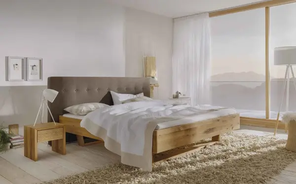 Modernes Schlafzimmer mit Holzbett, großen Fenstern und heller, gemütlicher Einrichtung.